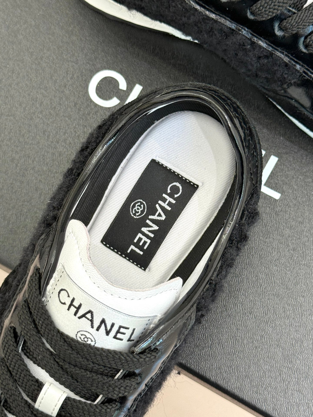 Chanel sneaker close-up showing CHANEL label on the white tongue lining