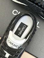 Chanel sneaker close-up showing CHANEL label on the white tongue lining
