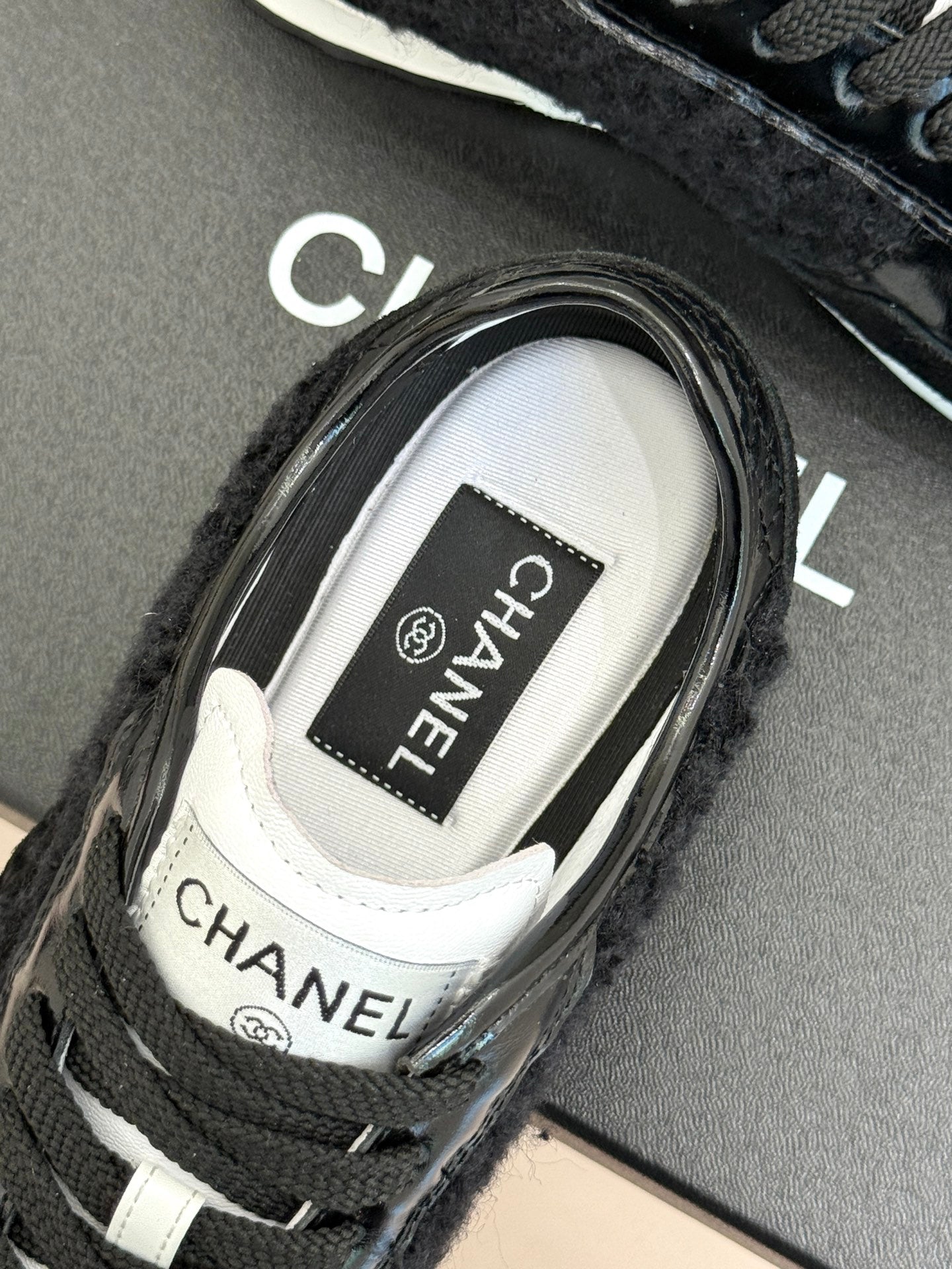 Chanel sneaker close-up showing CHANEL label on the white tongue lining