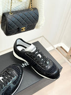Chanel black lace-up sneakers with textured uppers on display with matching bag