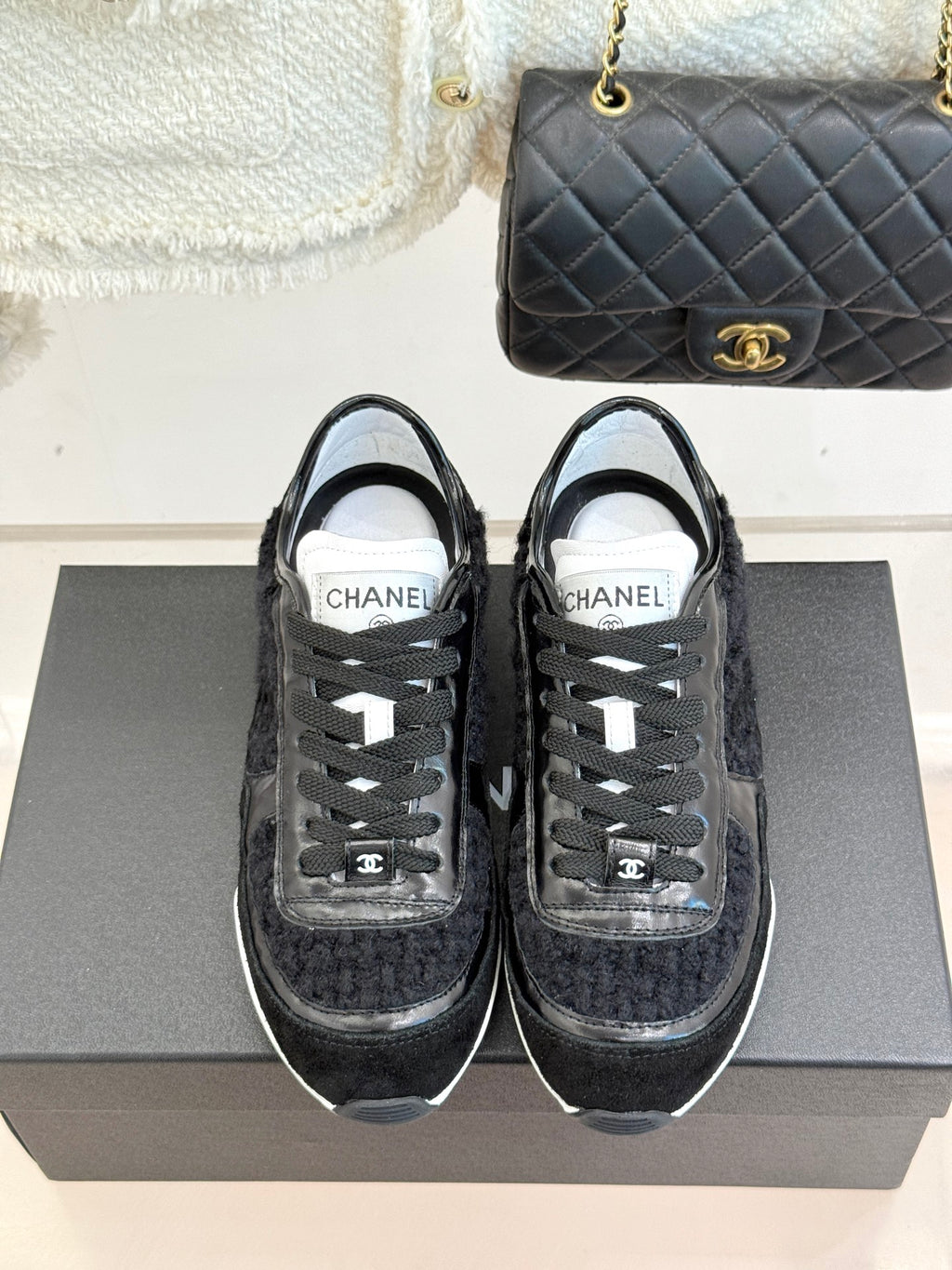 Chanel black sneakers with white-taped eyestays and lace-up front, front view