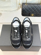 Chanel black sneakers with white-taped eyestays and lace-up front, front view
