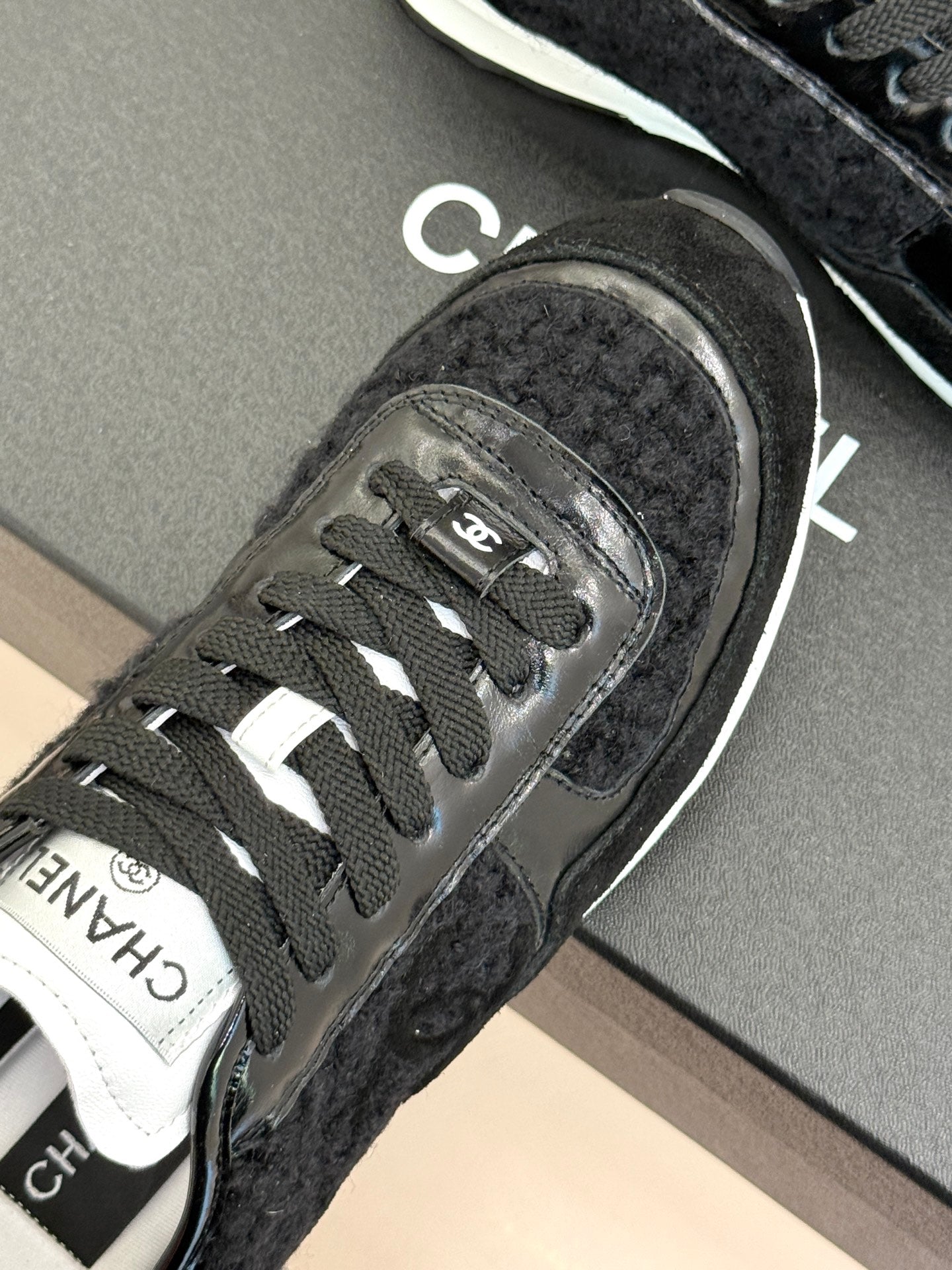 Chanel sneaker close-up of laces and CHANEL stripe logo on the side