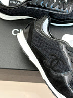 Chanel sneaker close-up: black textured panels with white midsole and laces