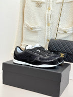 Chanel black low-top sneakers with lace-up front and white rubber sole
