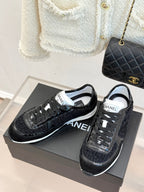 Chanel black low-top sneakers on shoe boxes with CHANEL logo detail