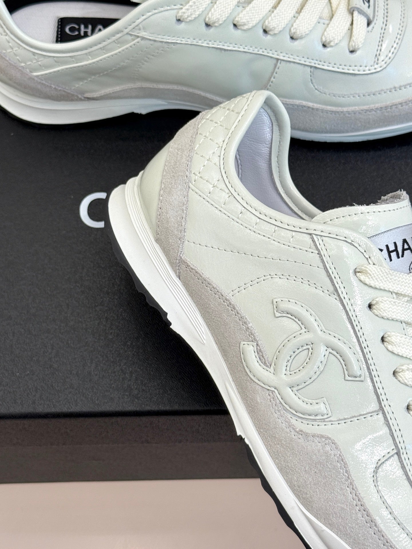 White Chanel sneakers close-up, suede panels and lace-up front