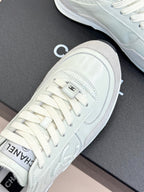 White Chanel sneakers close-up, laces and toe profile