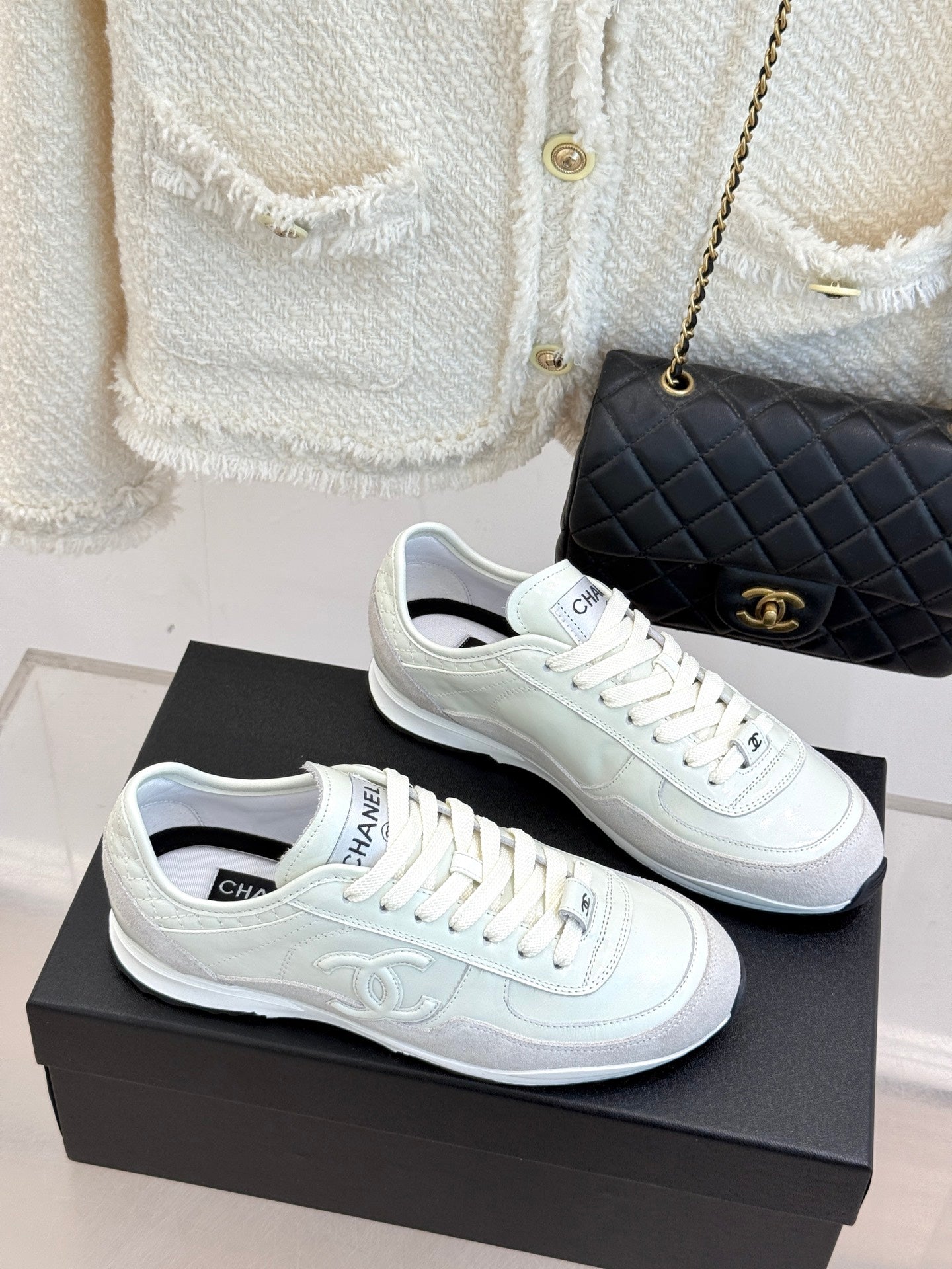 White Chanel sneakers with lace-up design and logo detailing