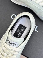 White Chanel sneaker close-up, branded tongue tag and lace-up