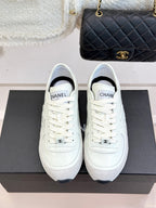 White Chanel low-top sneakers with white laces on black box