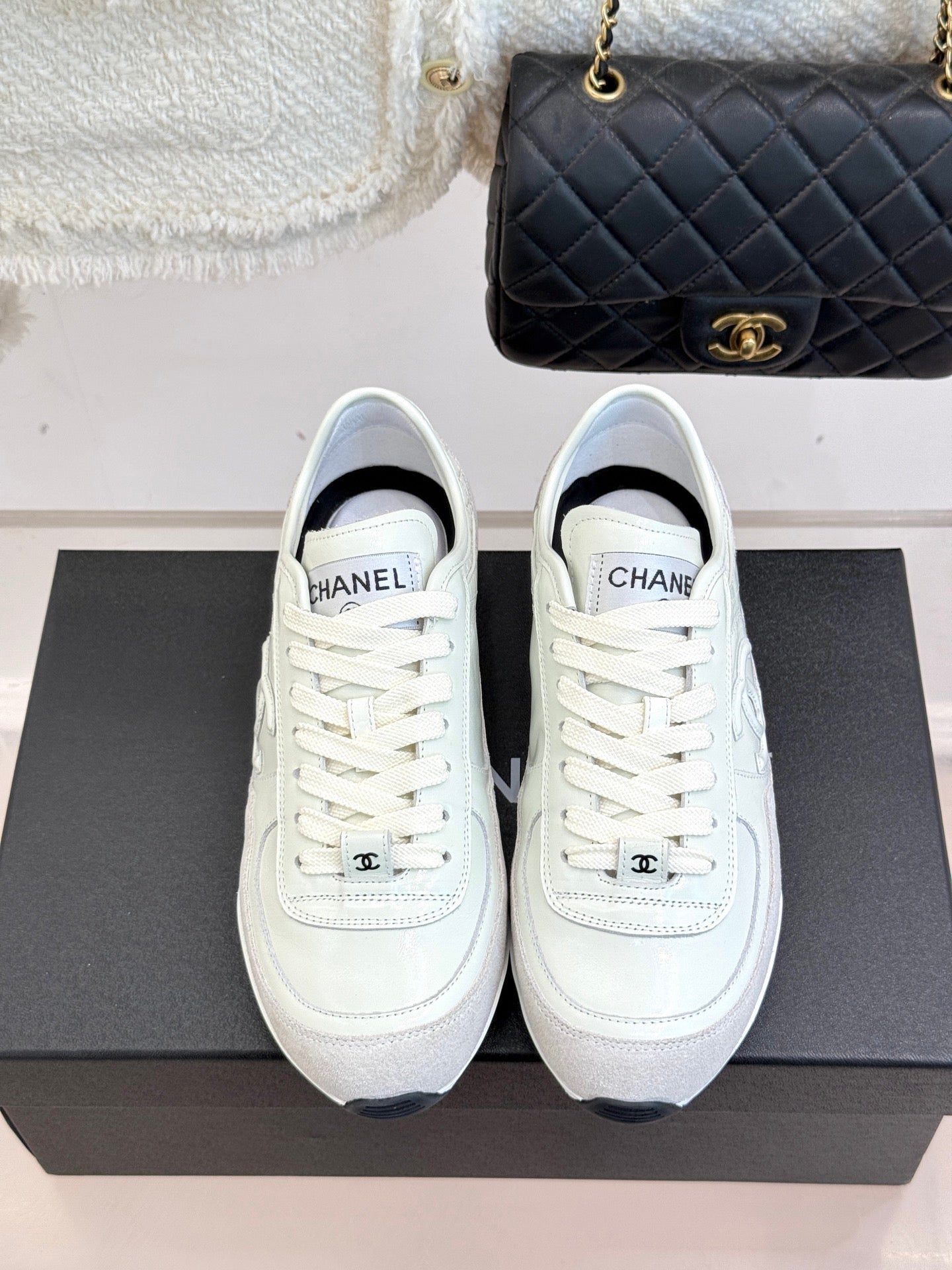 White Chanel low-top sneakers with white laces on black box