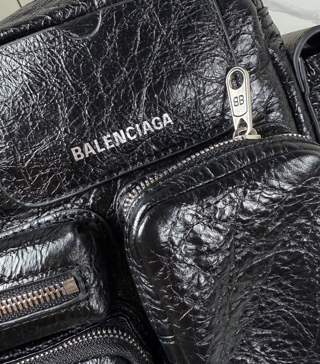 Balenciaga black leather bag closeup with BALENCIAGA logo and metal pull tab