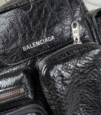 Balenciaga black leather bag closeup with BALENCIAGA logo and metal pull tab