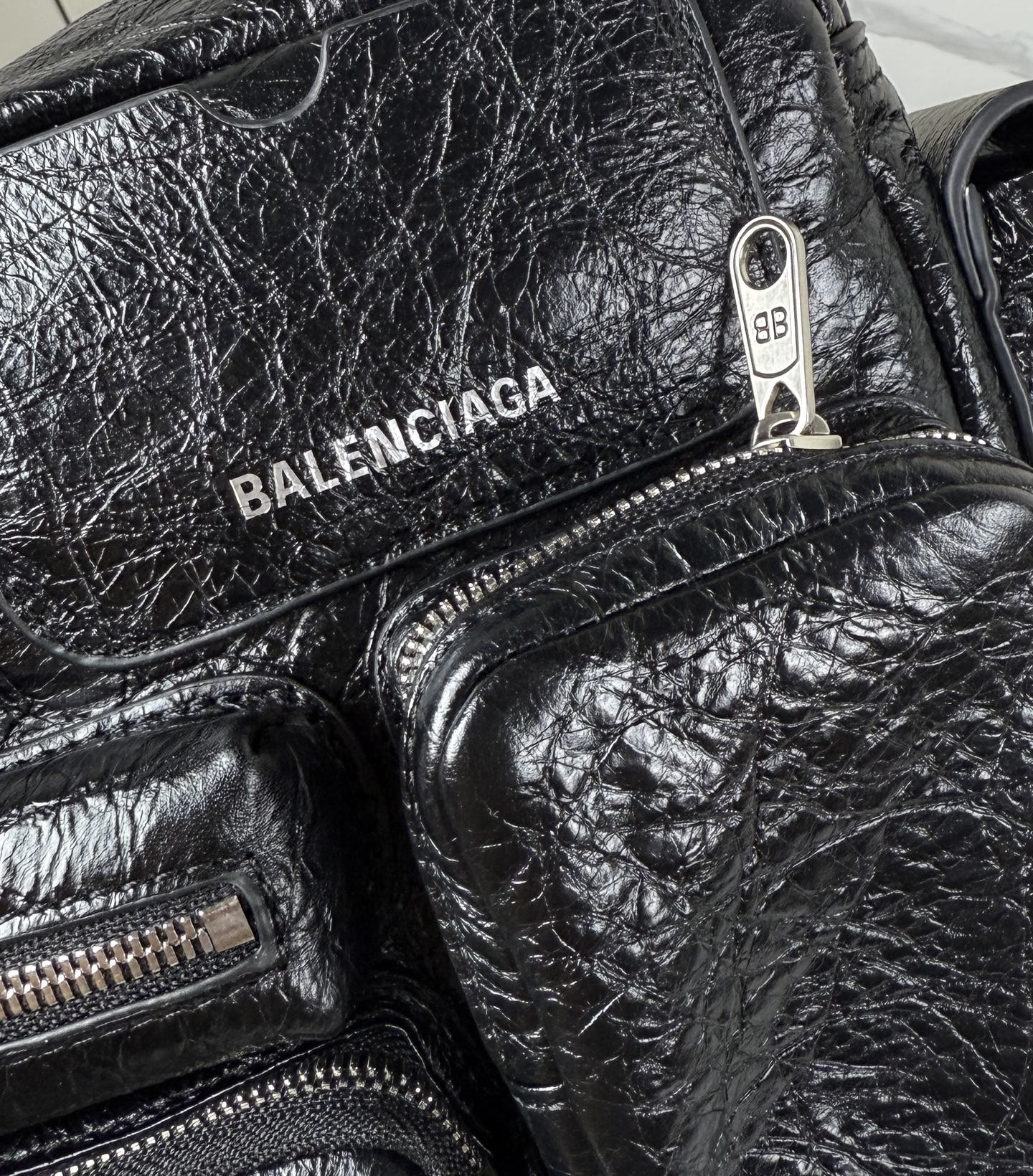Balenciaga black leather bag closeup with BALENCIAGA logo and metal pull tab