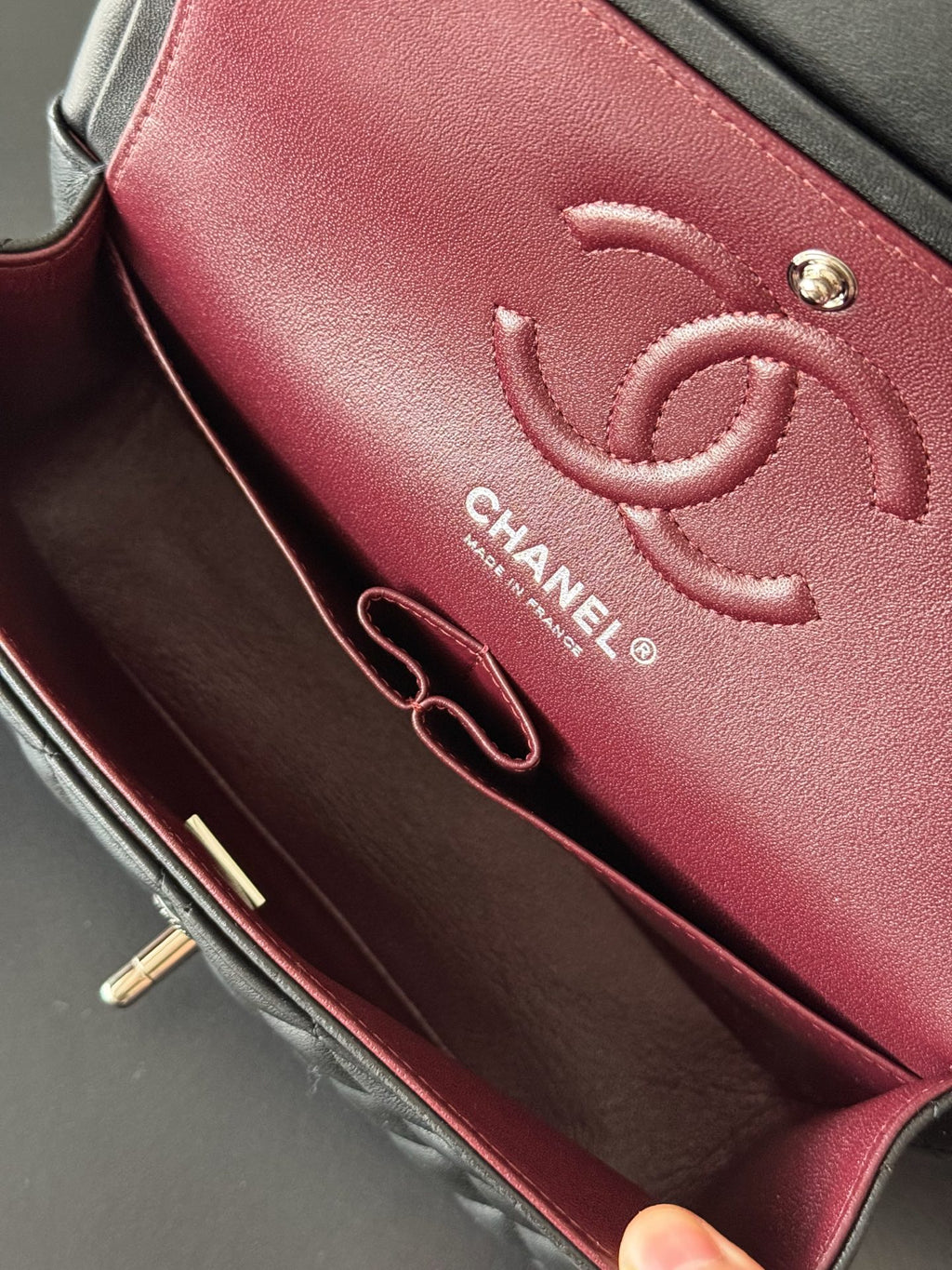Burgundy Chanel interior wallet section with CC logo and zipper pocket lining.