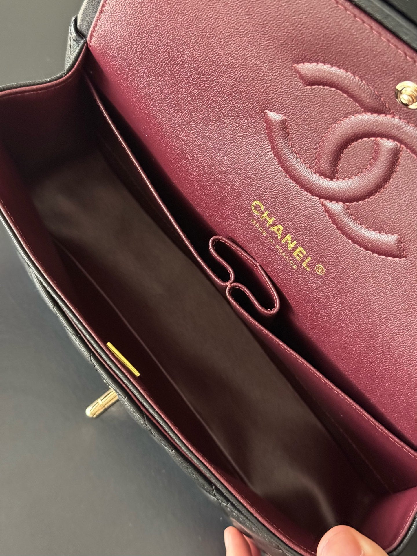 Chanel bag interior with burgundy lining and gold CC logo, open pocket detail