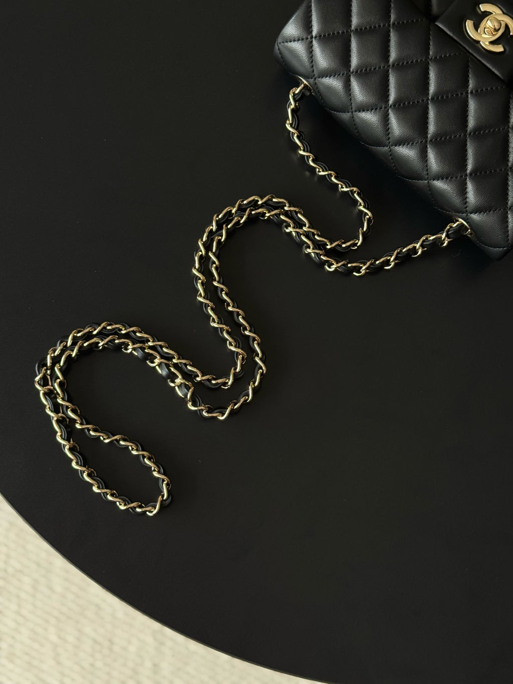Chanel quilted shoulder bag with gold chain lying beside it