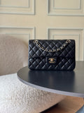 Black quilted Chanel flap bag with chain shoulder strap and gold-tone logo clasp