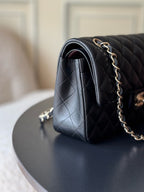 Black quilted Chanel shoulder bag with gold-tone chain strap and side seam detail