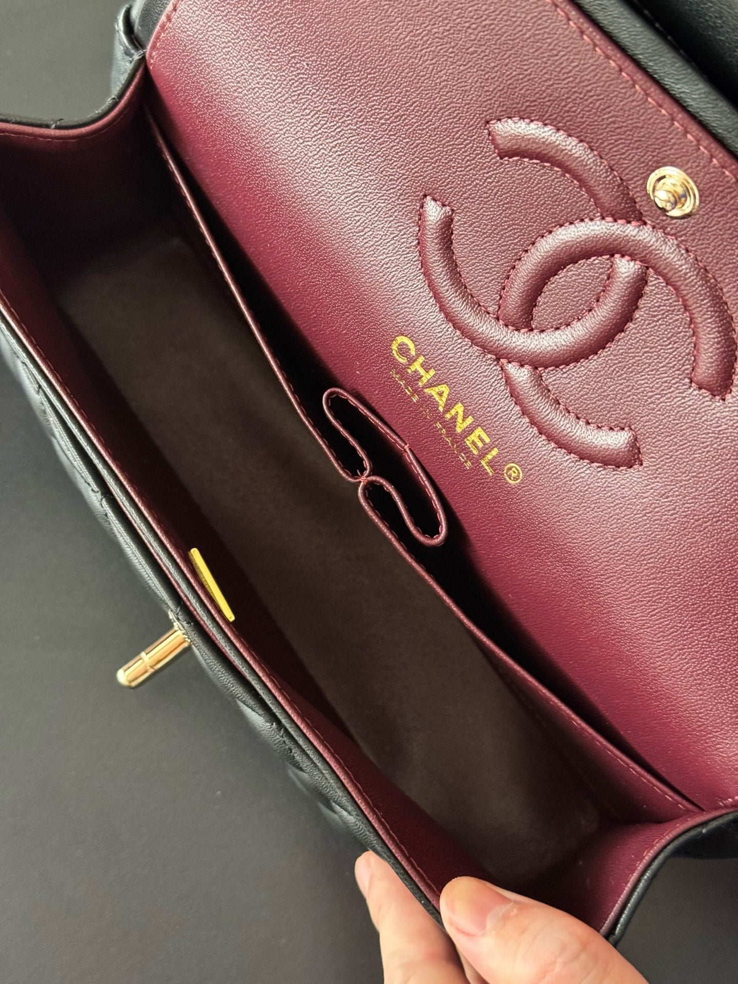 Maroon Chanel interior panel with embossed CC logo and engraved brand text