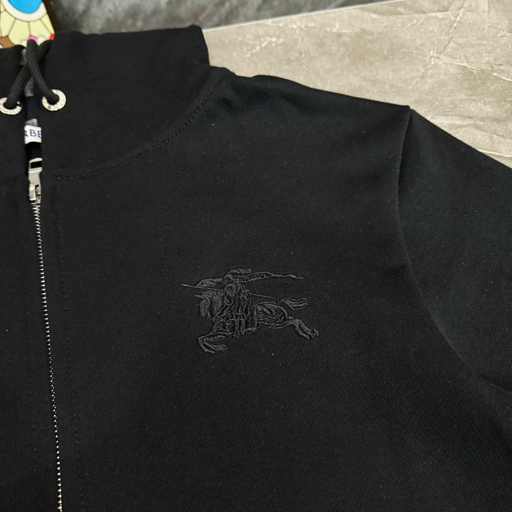 Black zip-up hoodie close-up with Burberry horse logo on chest