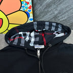 Black hoodie close-up: plaid hood lining with Burberry label and zipper