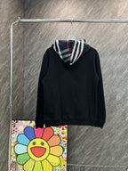 Black zip-up hoodie with drawstring hood and Burberry plaid lining