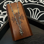 Chrome accessories silver-tone necklace with central pendant on wooden display stand