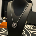 Chrome Accessories necklace with round pendant on silver chain, close-up on bust.