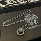 Chrome Accessories pendant necklace with round charm on textured box surface.