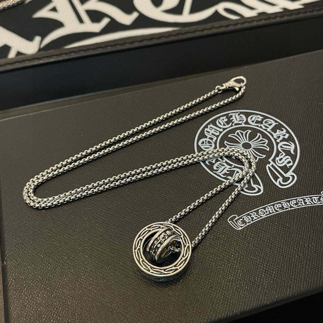 Chrome Accessories pendant necklace with round charm on textured box surface.
