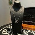 Chrome Accessories necklace with round pendant and silver chain on black bust display.