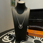 Chrome Accessories necklace with round pendant and silver chain on black bust display.