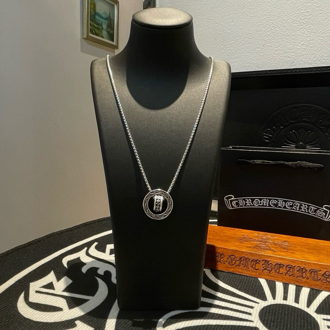 Chrome Accessories necklace with round pendant and silver chain on black bust display.