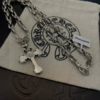 Silver cross pendant necklace on pouch with layered chain and charm details