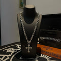 Silver chain cross pendant necklace on black display stand