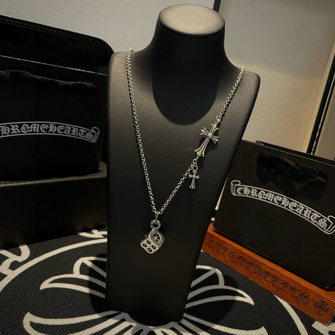 Silver chain charm necklace with cross charms and round pendant on a mannequin