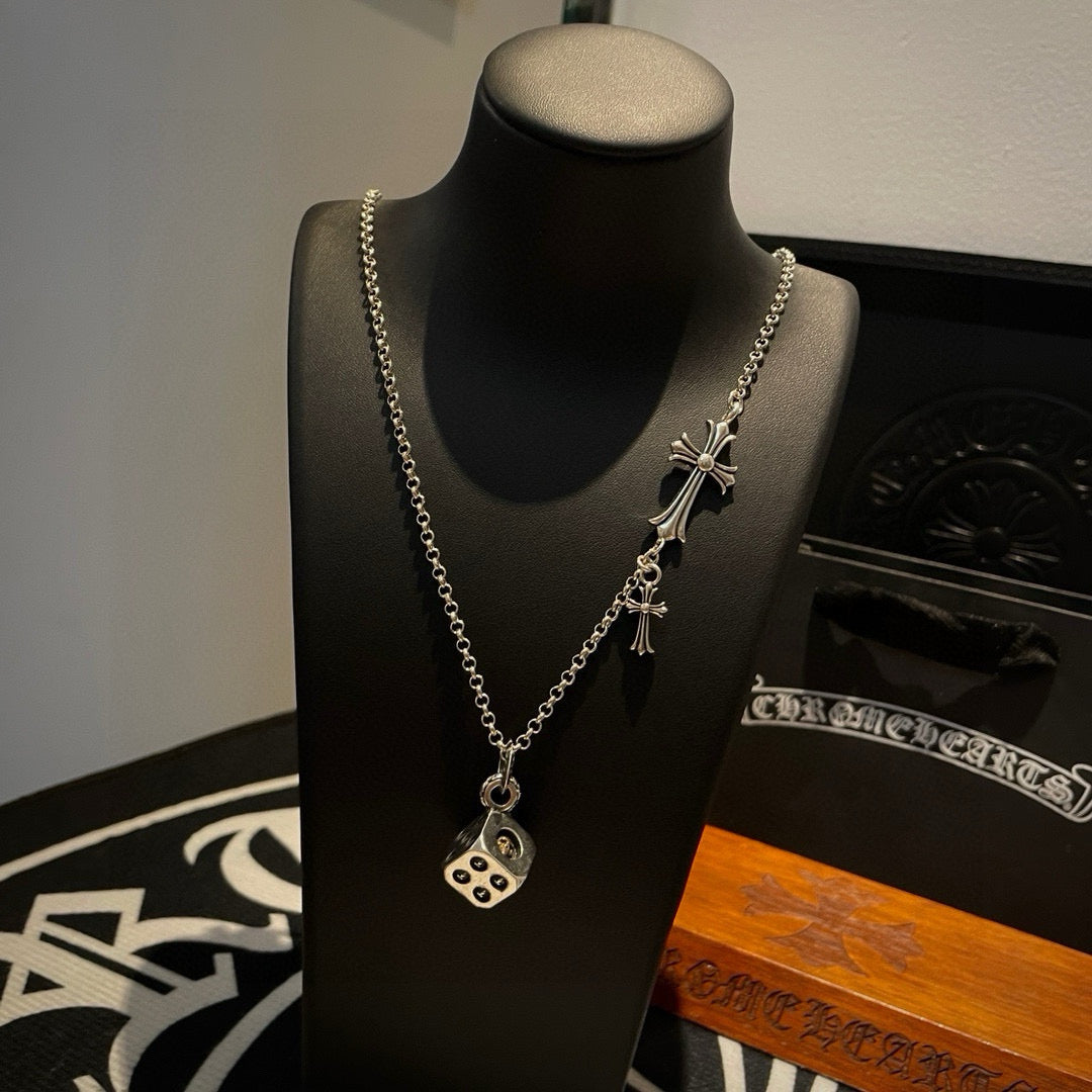 Silver cross charm necklace with round pendant on a mannequin display stand