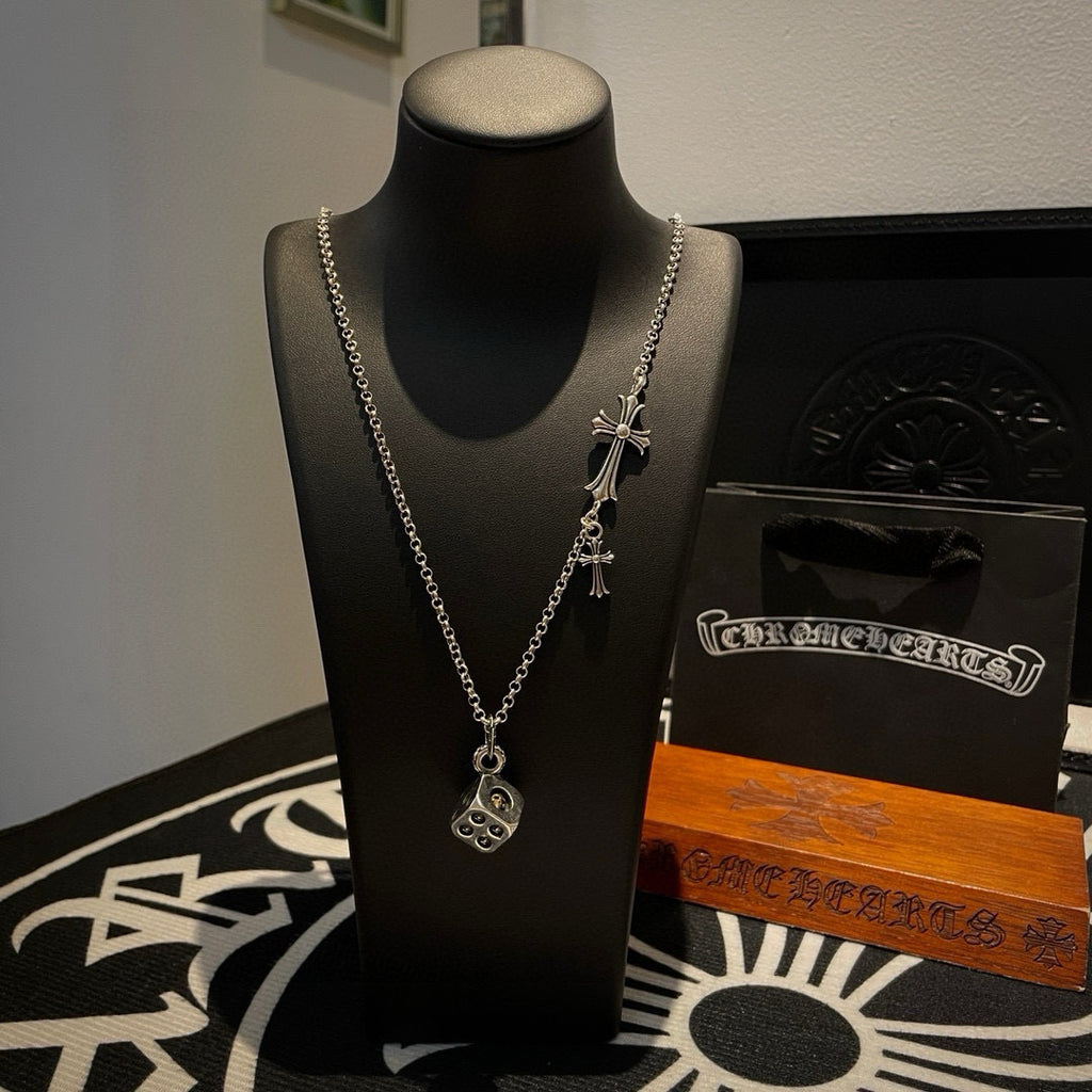 Silver charm necklace with cross and round pendant on a mannequin