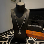 Silver charm necklace with cross and round pendant on a mannequin