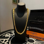 Gold tone chain necklace on a black jewelry stand, layered links