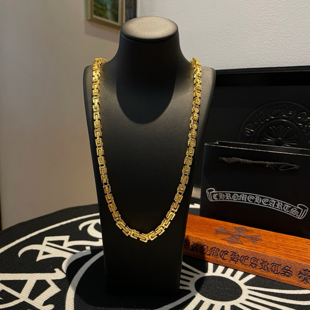 Gold tone chain necklace on a black jewelry stand, layered links