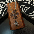 Silver-tone chain necklace with cross pendant on wooden box