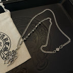 Silver-tone chain necklace with cross pendant on jewelry box