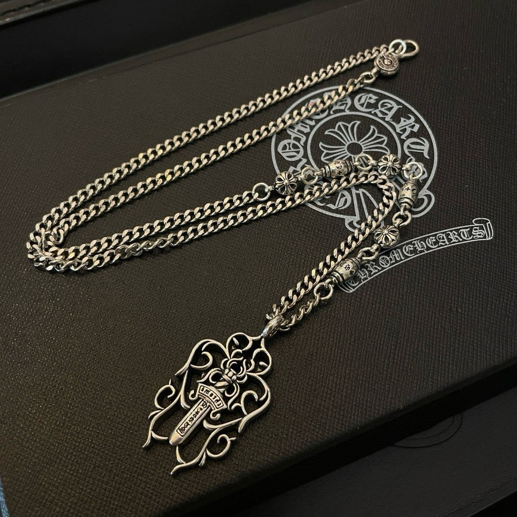 Silver-tone chain necklace with floral cross pendant and charms