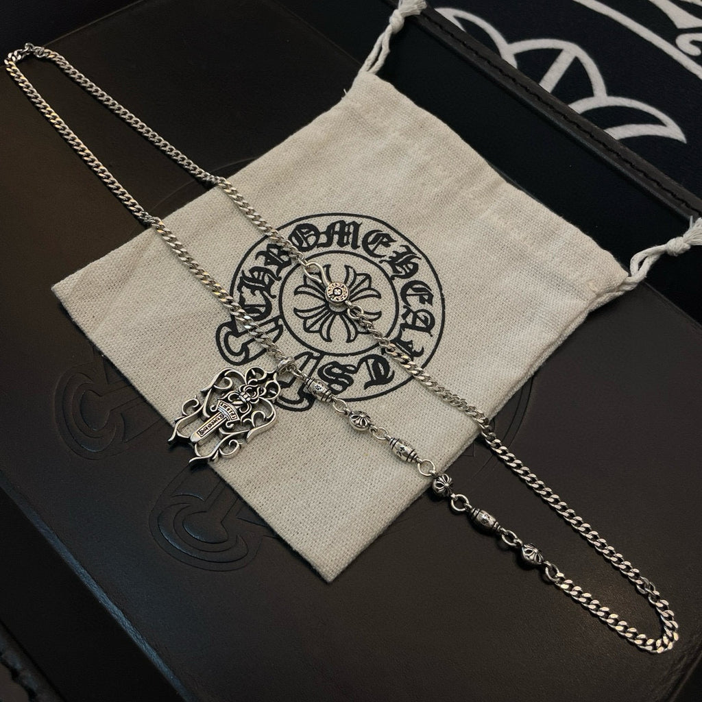 Silver-tone chain necklace with cross pendant on fabric pouch
