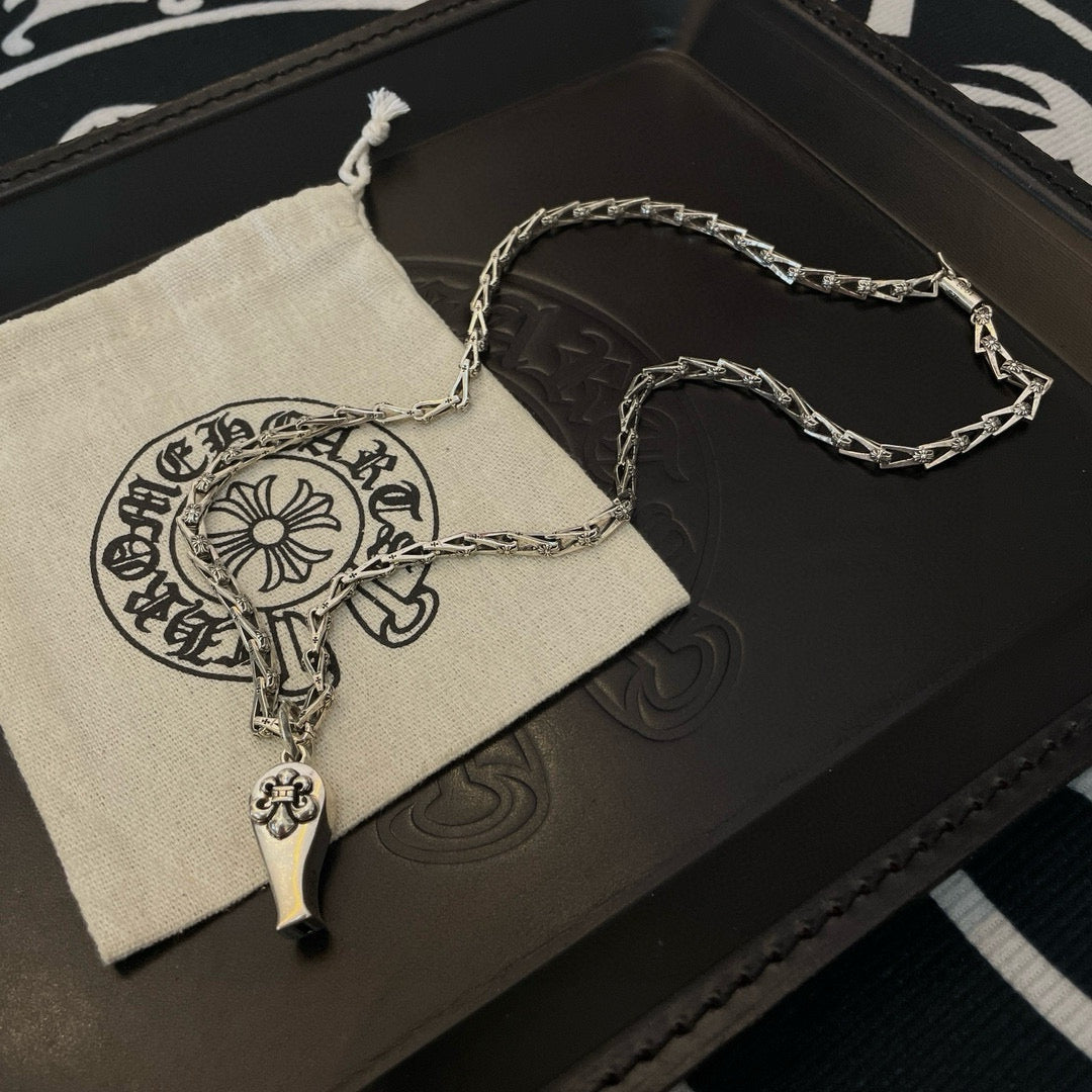 Silver-tone chain necklace with charm pendant, over fabric pouch in box