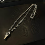 Silver-tone chain necklace with charm pendant, close-up on embossed black leather