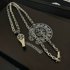 Silver-tone chain necklace with charm pendants, laid across black case